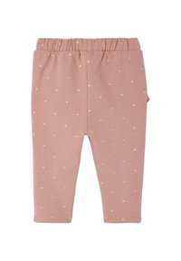 Helle rosa Baumwollleggings mit einem dehnbaren Bündchen und kleinen, goldenen Herzmustern überall. Sie haben ein einfaches Design und eine glatte Textur.