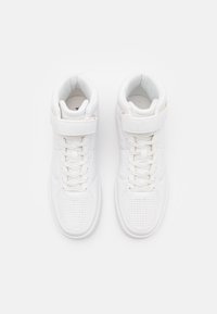 Weiß lederne High-Top-Sneaker mit perforierter Zehenpartie, gepolstertem Knöchel, flachen Schnürsenkeln und einem Klettverschluss für zusätzlichen Halt.