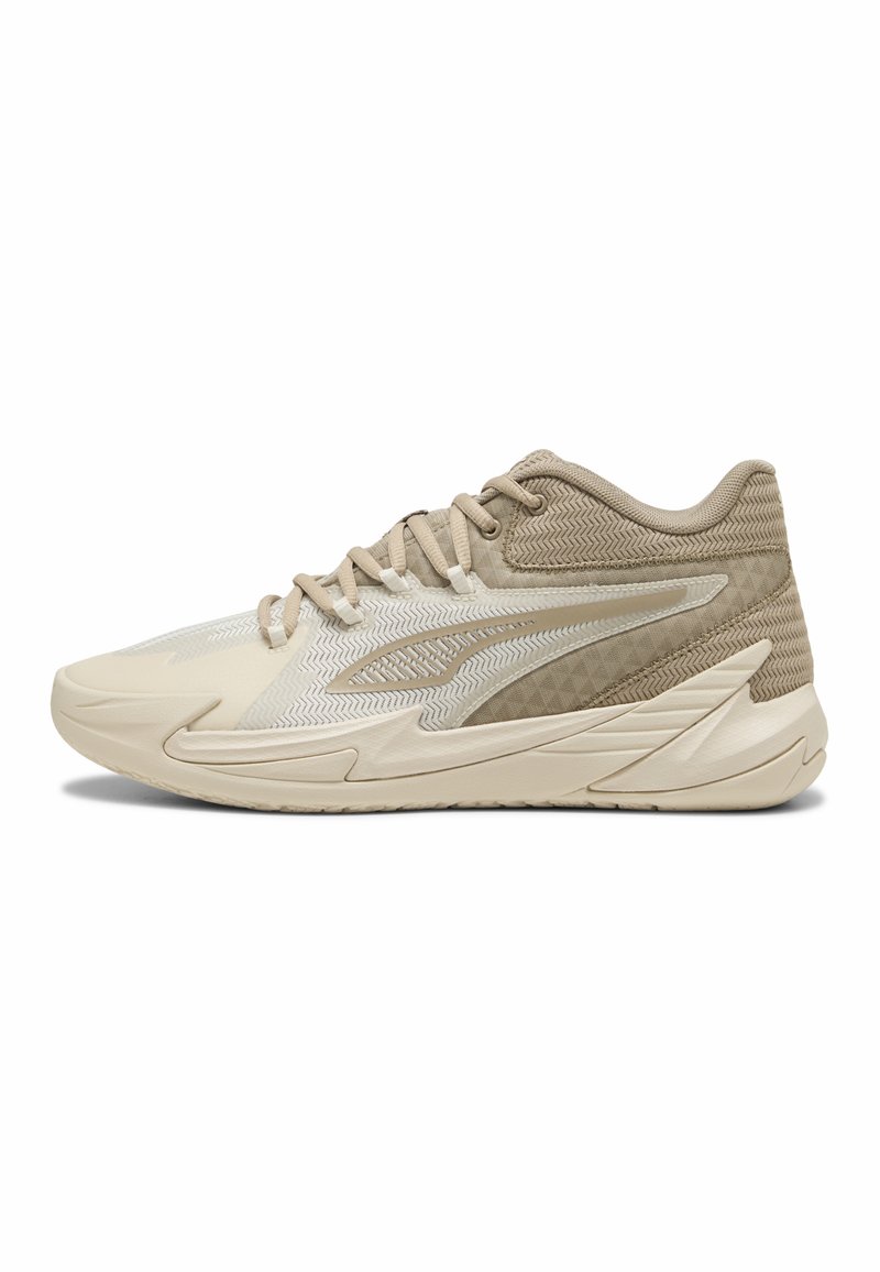 Beige sportsko med mesh og tekstiloverdel, teksturerede accenter, rund tå og tyk gummisål for støtte. Har et neutralt farveskema.