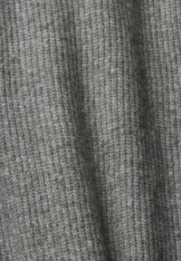 Tissu tricoté gris avec une texture côtelée, d'épaisseur moyenne et présentant des variations subtiles de teinte.