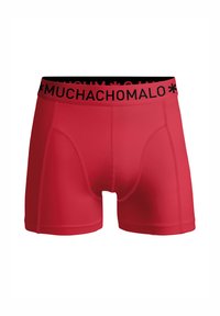 Punaiset bokserit joustavasta materiaalista, mustalla vyötärönauhalla, jossa on "MUCHACHOMALO" -logo. Sujuva pinta, tiukan muotoinen ja ilman näkyviä kuvioita.