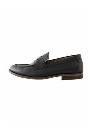 Mocasines de cuero negro con puntera redondeada, que presentan una correa decorativa en el empeine y un tacón de madera bajo. Acabado texturizado.