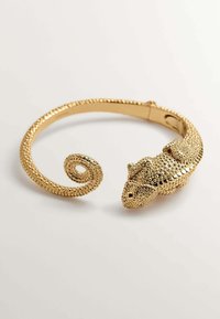 Pulsera de tobillo de color dorado con un diseño texturizado de camaleón en un extremo y una cola enrollada, fabricada con material metálico.