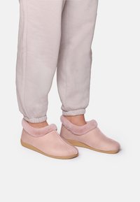 Rozā čības ar teksturētu virsmu un mīkstu, pūkainu apkakli. Gumijas zoles un eleganta forma papildina ērtu fit.