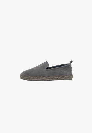 Mocasín gris de gamuza sin cordones con entresuela trenzada de yute y suela de goma, que cuenta con una lengüeta en la parte trasera y un diseño de perfil bajo.