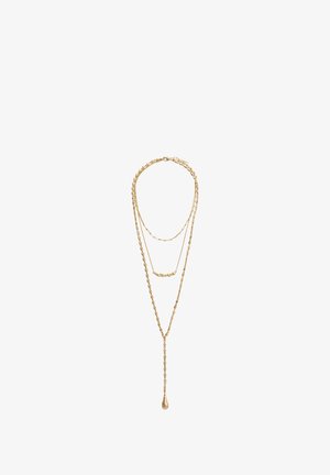 Dreilagige goldene Halskette mit unterschiedlichen Gliedstilen, einschließlich eines Tropfenspendants, das von der längsten Kette hängt.