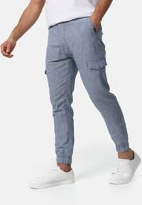 Lyseblå cargobukser med tilspidset pasform, elastiske manchetter, to sidelommer og en sidelomme til ekstra funktionalitet. Fremstillet af blødt stof.