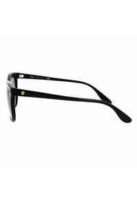 Occhiali da sole neri con una montatura robusta, dotati di lenti rotonde, tempie eleganti e un'accortezza del logo giallo sul lato.