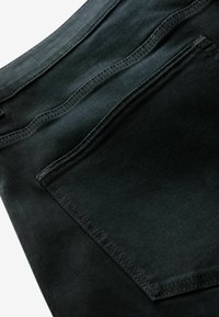 Zwarte denim jeans met een achterzak voorzien van een schone stiknaad. De stof lijkt glad met een lichte glans.