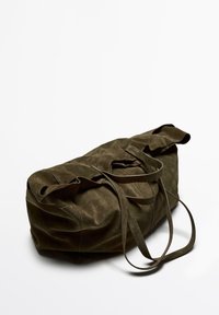 Olijfgroene suede sporttas met twee lange handvatten en een zachte, gestructureerde oppervlakte. Beschikt over een ronde vorm met zichtbare naaddetails.