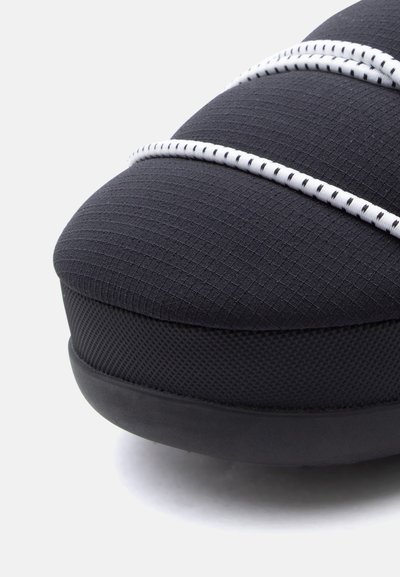 Μαύρο αθλητικό παπούτσι με υφασμένο επάνω μέρος και λευκές διακοσμητικές λωρίδες, στρογγυλεμένη μύτη και λείο ελαστικό πέλμα. Υλικά υψηλής ποιότητας με ξεχωριστά σχέδια.