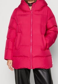 Chaqueta acolchada fucsia con capucha, que cuenta con cremallera frontal, costuras horizontales y bolsillos laterales. Fabricada con material brillante y ligero.