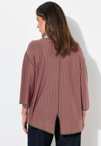 Gestreiftes Tunika in Grün und Pink, mit lockerem Schnitt, weiten Ärmeln und einem Schlitz auf der Rückseite für mehr Bewegungsfreiheit. Weicher Strickstoff.