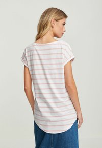 Randig t-shirt i vitt och ljusrosa, med rullade korta ärmar och rundad nederkant. Mjuk bomullsmaterial, avslappnad passform.