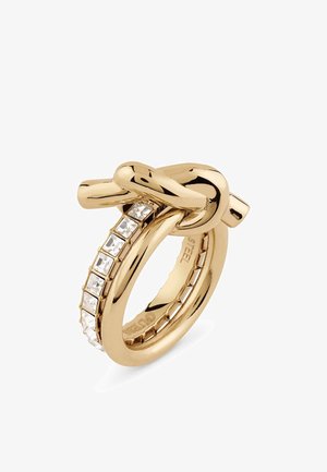 Goldfarbener Ring mit einem geknoteten Design und einer Reihe quadratischer Kristallakzente auf einer Seite. Glatte, polierte Metalloberfläche.