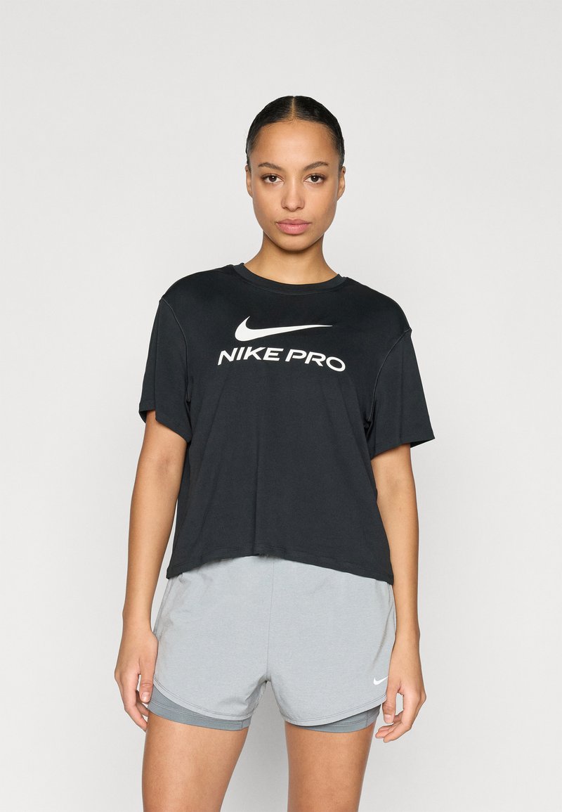 Μαύρο κοντομάνικο Nike Pro t-shirt με λευκό λογότυπο. Συνδυάζεται με γκρι αθλητικές βερμούδες, που παρουσιάζουν λείο, ελαφρύ ύφασμα.