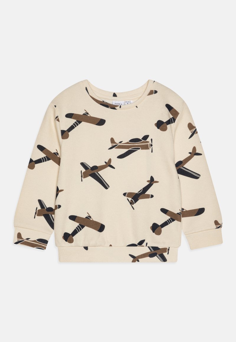 Lys beige genser med et gjentakende mønster av vintage fly i brunt og svart. Ribbestrikkede mansjetter og kant. Myk stofftekstur.