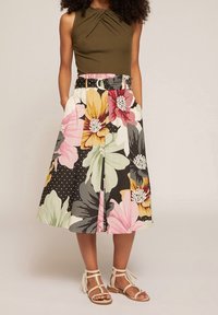 Floral midi skirt featuring large pink, yellow, and green flowers on a black background, with a belted waist and side pockets.