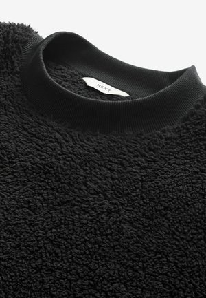 Schwarzer Fleece-Sweatshirt mit strukturierter Oberfläche und geripptem schwarzen Rundhalsausschnitt, mit sichtbarem Etikett innen.