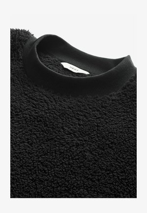 Juodas šviesus džemperis, turintis tekstūruotą paviršių ir juodą kanalėlių apykaklę, su matomu etikete viduje.