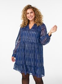 Mörkblå klänning med vågigt fåll, genomskinliga långa ärmar och vertikalt vitt randmönster. V-ringning med knapplandning framtill.