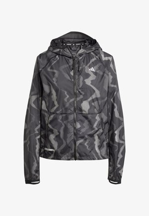 Zwarte hardloopjack met een camouflagepatroon in witte stippen, voorzien van een ritssluiting aan de voorkant, een capuchon en elastische manchetten. Lichtgewicht, ademend materiaal.