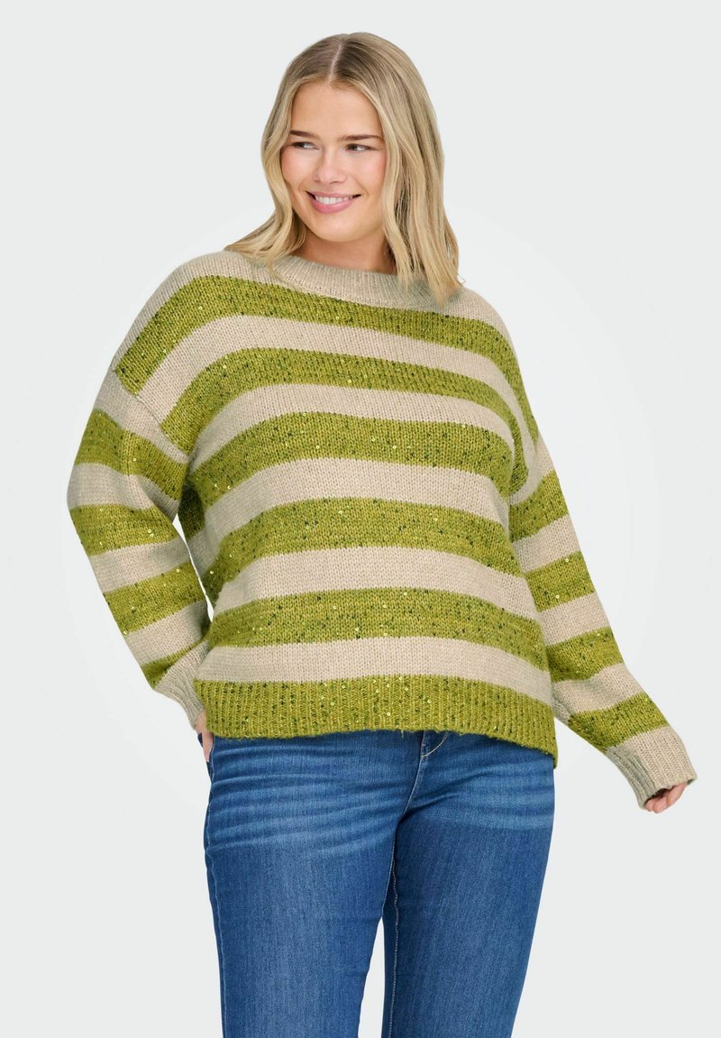 Gebreide trui met groene en beige horizontale strepen, met een textuur afwerking. Het heeft een wijde halslijn en een losse pasvorm. Gecombineerd met blauwe jeans.