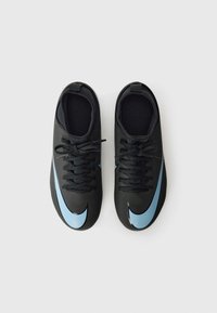 Black athletic shoes with a sleek design, featuring a large light blue Nike swoosh, round toe, and lace-up closure. Textured surfaces, no patterns.