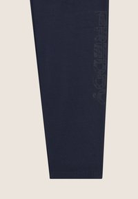 Leggings in cotone blu navy con un design aderente. Presentano un logo testurizzato, "FREDDY," stampato verticalmente lungo il lato sinistro. Tessuto morbido.