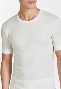 T-shirt bianco a maniche corte con scollatura rotonda e bordature a contrasto. Realizzato in tessuto morbido con una texture liscia, presenta un design aderente.