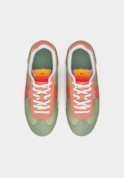 Ζευγάρι πράσινων και ροδακινί αθλητικών παπουτσιών με λευκά κορδόνια, πολύχρωμες ετικέτες στη γλώσσα που γράφουν "PS Paul Smith", από πάνω σε λευκό φόντο.