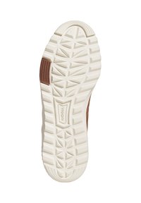 Weißer Gummisneakerboden mit dreieckigen Profilmustern; verfügt über einen braunen Akzent in der Nähe der Ferse. Strukturierte Oberflächen verbessern den Grip und die Haltbarkeit.