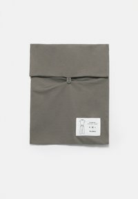 Šedý látkový sáček s knoflíkovým zapínáním, uvnitř pyžamový set. Obsahuje štítek s informacemi o produktu: „Pyžamový set, bavlněné tričko a kalhoty, S M L.“