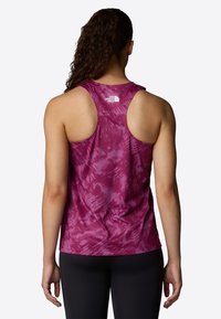 Magenta tank top with a tie-dye pattern and a racerback design. The fabric appears lightweight, with a logo on the upper back.
