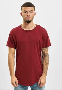 Bordeaux crew-neck t-shirt med korte ærmer og buet kant. Lavet af blødt stof, har en afslappet pasform og minimalistisk design.