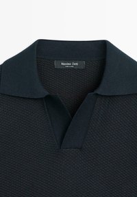 Polo in maglia nera testurizzata con collo a coste e scollo a V aperto, con etichetta Massimo Dutti all'interno del collo.