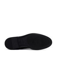 Suela de zapato negra con una superficie lisa y un patrón de agarre texturizado. Presenta una forma redondeada y un color negro uniforme en toda su extensión.