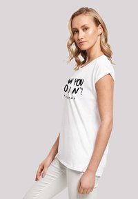 White cotton t-shirt with rolled sleeves, featuring a black graphic print that reads "HOW YOU DOIN'?" on the front. Smooth texture.
