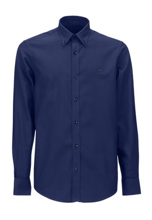 Camisa de manga larga azul marino con cuello abotonado, botones negros y un pequeño logo en el lado izquierdo del pecho, hecha de una tela suave.
