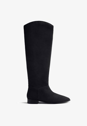 Bota de ante negra hasta la rodilla con punta afilada, tacón plano y textura suave. Diseño minimalista sin hardware ni acentos visibles.