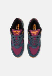 Sneakers Saucony mają niebieską i burgundową siateczkę, szare akcenty oraz pomarańczowe detale, a także wyściełany kołnierz i sznurowadła.