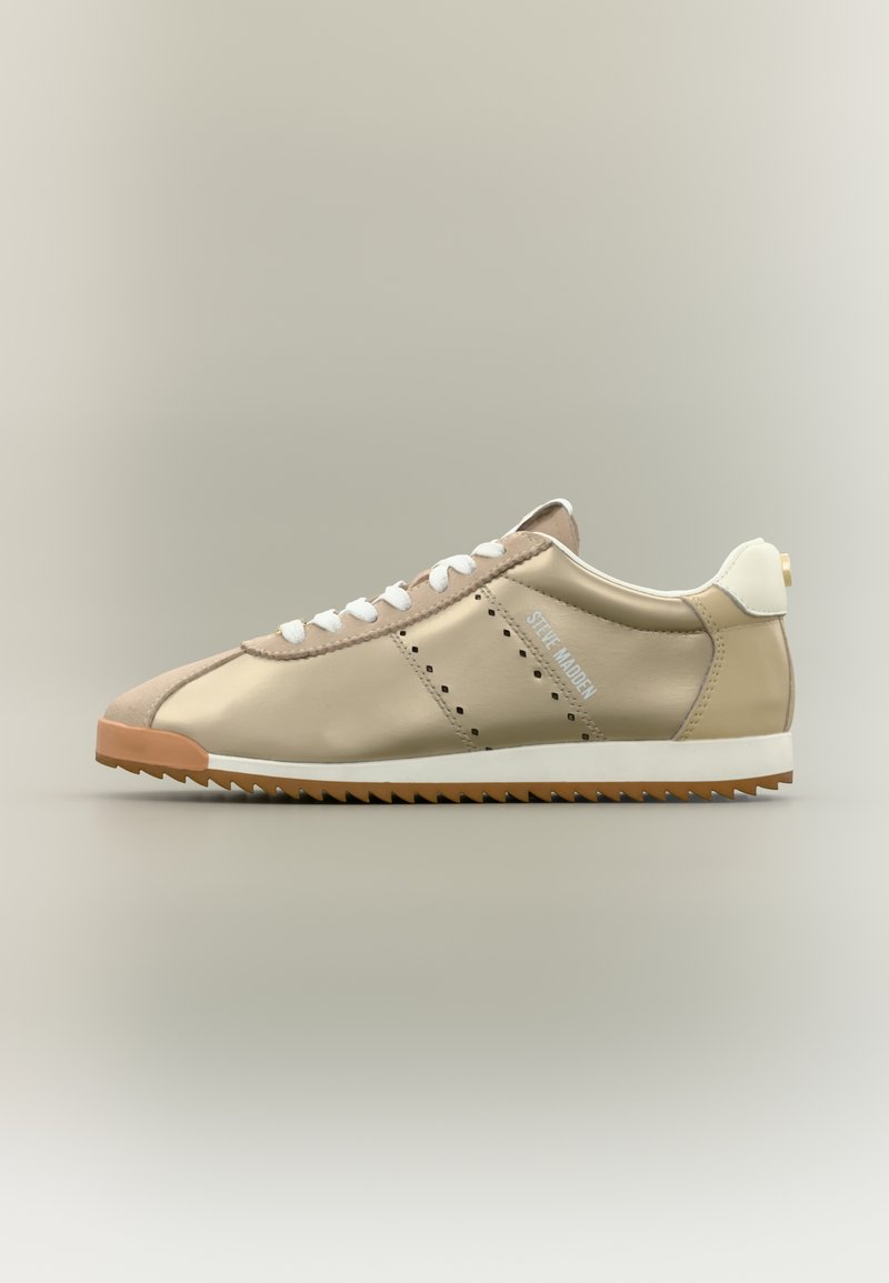 Baskets synthétiques beige avec lacets blancs, détails perforés et semelle en caoutchouc couleur miel ; dotées d'un accent blanc au talon avec logo.