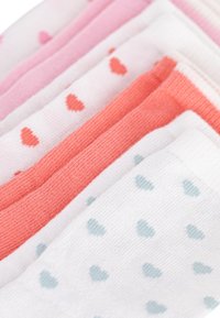 Πέντε ζευγάρια κάλτσες τοποθετημένα δίπλα το ένα στο άλλο. Τα χρώματα περιλαμβάνουν ροζ, κοραλί και λευκό, με μικρά σχέδια καρδιάς σε αντίθετα χρώματα.