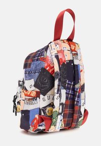 Pestrobarevný patchwork batoh s červenými popruhy, obsahující různé textury látek a potisky loga v denimu, kostkovaném vzoru a grafických designech.