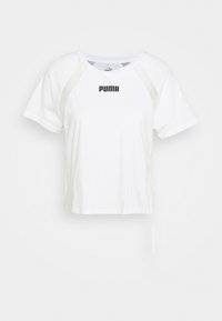 Camiseta blanca recortada de manga corta, con un logo negro "PUMA" en el frente y un detalle de lazo en el costado. Material de algodón suave.
