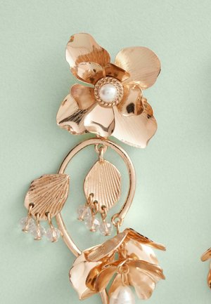 Goldfarbene Ohrringe mit floralen Motiven, die eine zentrale Blume mit einer Perle, kunstvoll gestaltete Blattformen und herabhängende Kristallperlen zeigen.