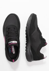 Un paio di scarpe sportive leggere Skechers nere con tessuto a rete, suole interne in memory foam e accenti rosa su uno sfondo bianco.