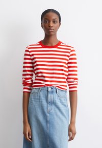 Rot-weißer gestreifter Langarmshirt mit Rundhalsausschnitt, kombiniert mit einem hellblauen hoch taillierten Jeansrock. Aus weichem Baumwollmaterial.