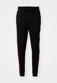 Zwarte joggingbroek met een trekkoord in de taille, voorzien van rode strepen aan de zijkanten en geribde boorden. Gemaakt van zachte, gestructureerde stof.