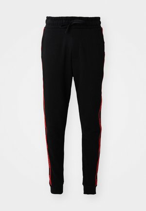 Black sweatpants with a drawstring waist, featuring red stripes on the sides and ribbed cuffs. Made from soft, textured fabric.
